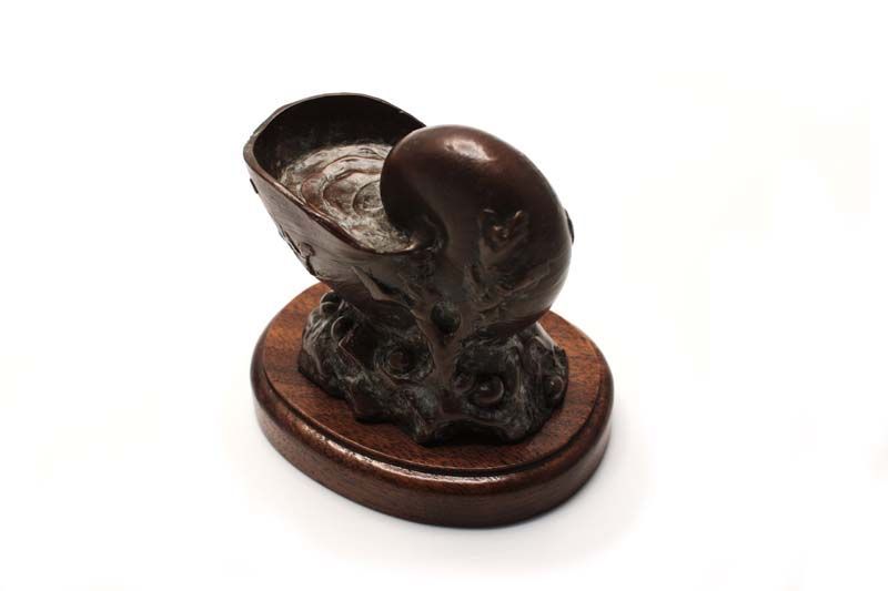 A statue of a snail on a wooden base