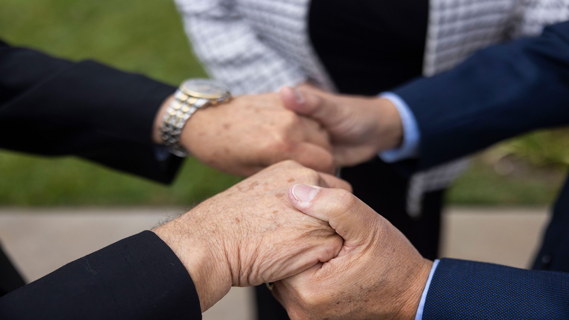 A group of people are putting their hands together.