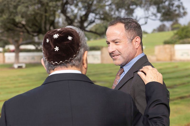 A man in a suit is standing next to another man in a