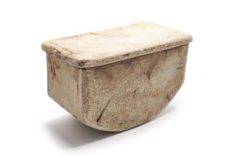 A wooden box with a lid is sitting on a white surface.