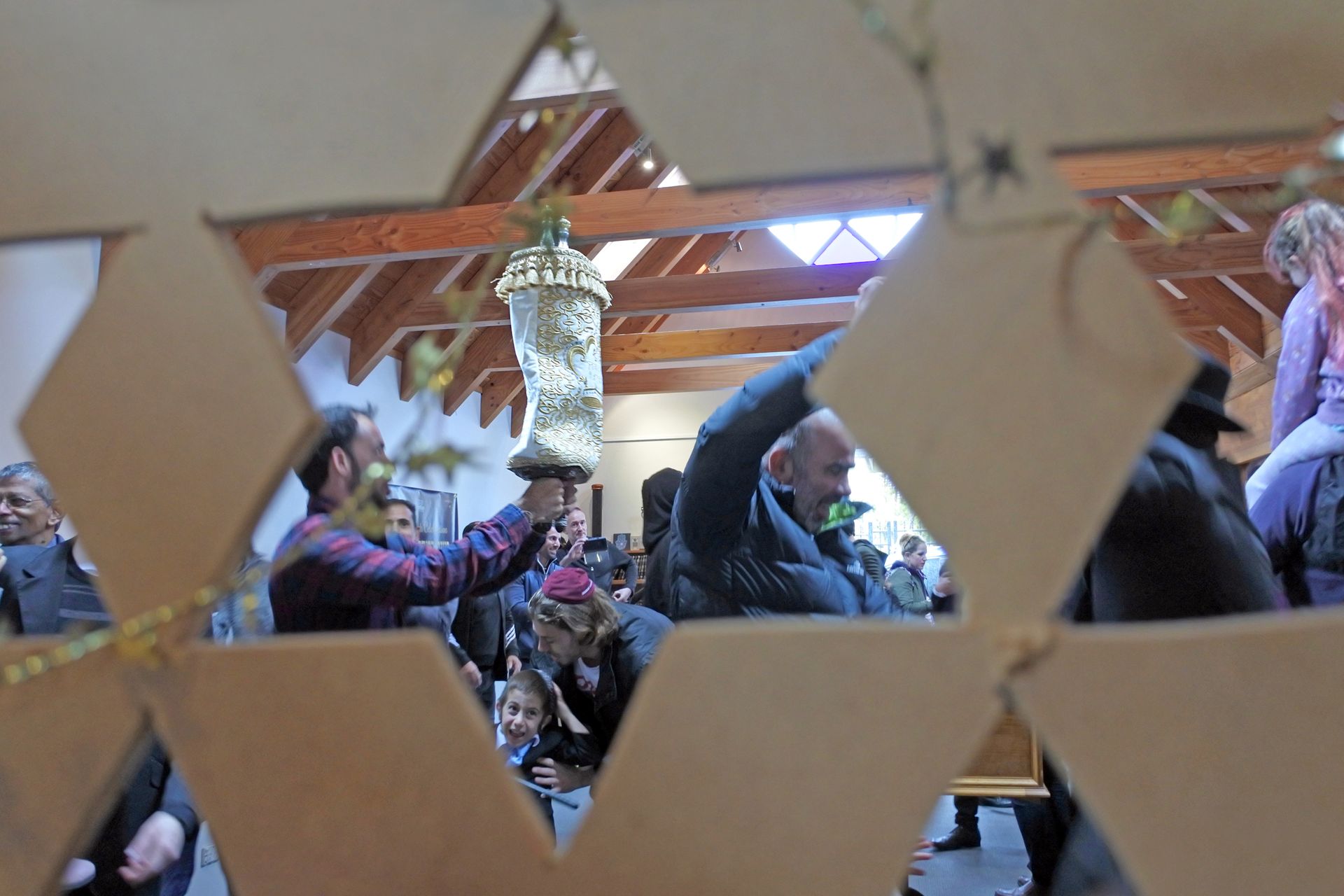A group of people are standing in a room behind a cardboard fence.