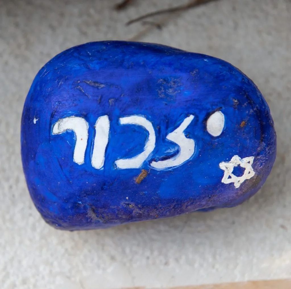 A blue rock with the word scil painted on it