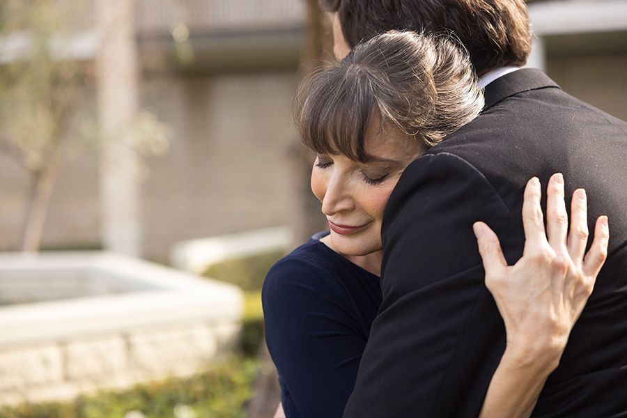 A woman is hugging a man in a suit.