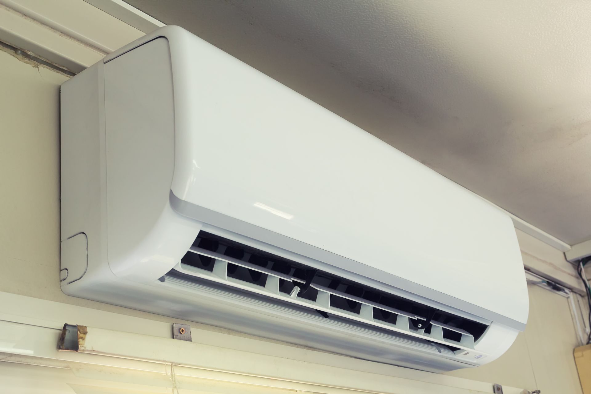A white wall-mounted air conditioner unit installed near the ceiling.