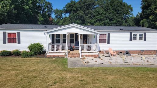 An aerial view of a mobile home with a porch and a patio.