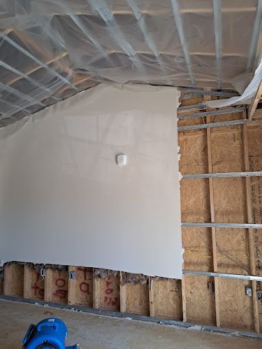 A room with a white wall and a ladder in it.