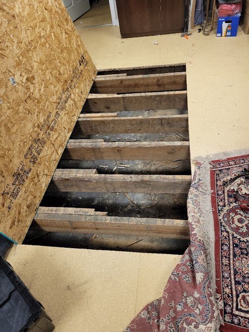 A room with a wooden floor and a rug on the floor.