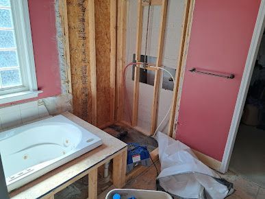 A bathtub is sitting on top of a wooden table in a bathroom under construction.