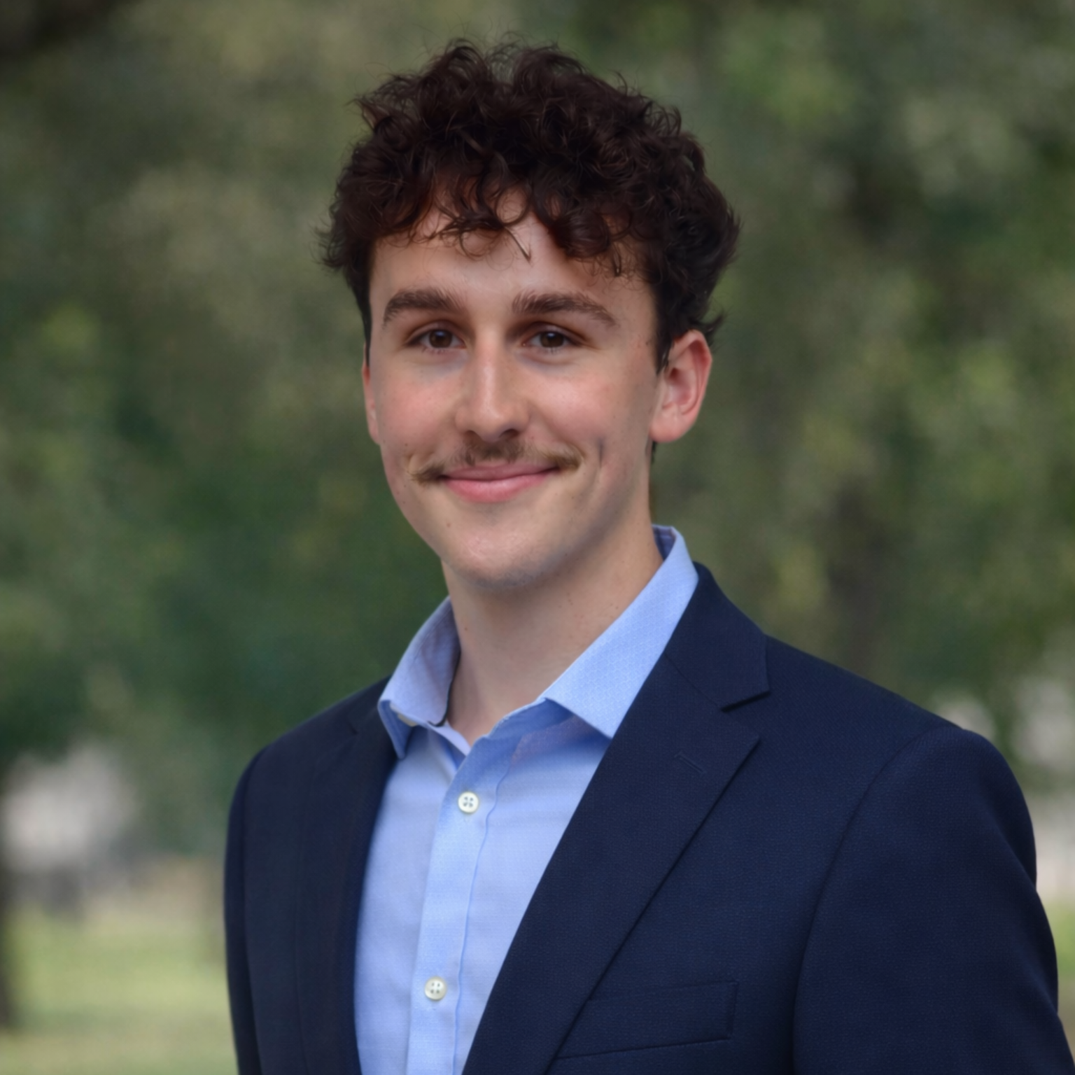 Smiling man in a blazer, headshot.