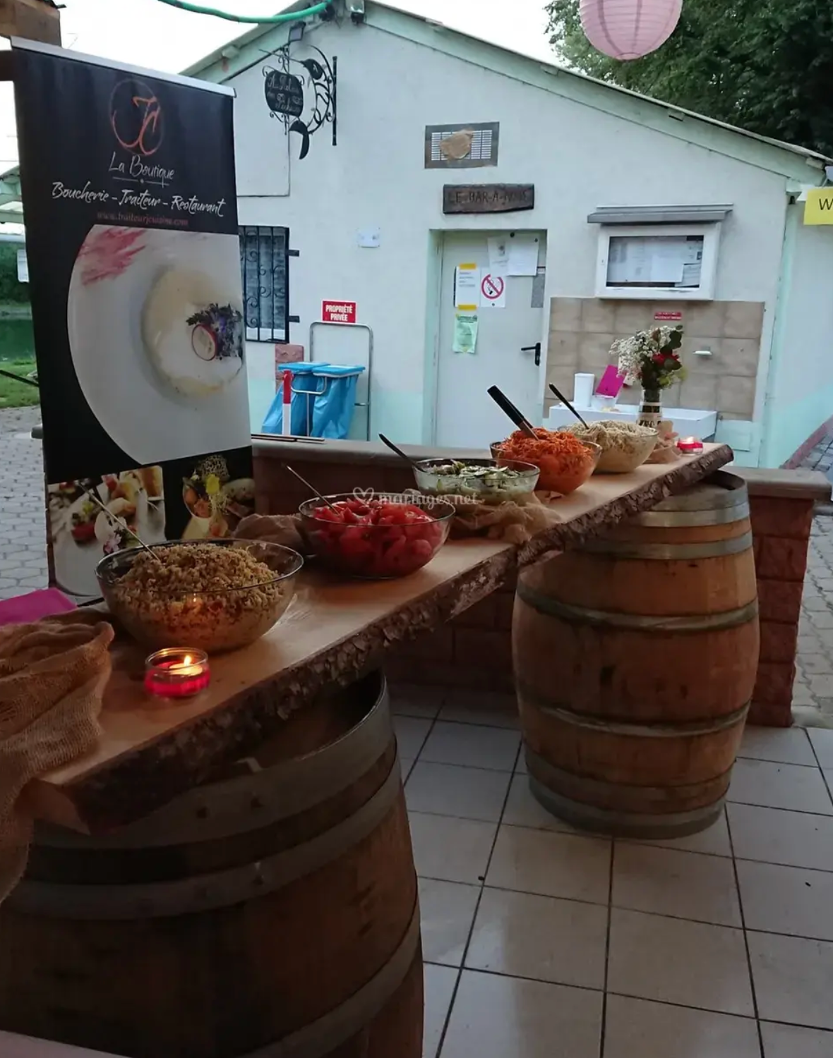 Une table de buffet avec des tonneaux en bois et des bols de nourriture