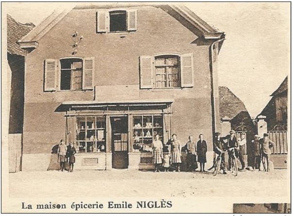 Une photo en noir et blanc d'un magasin appelé la maison epicerie emile nigle
