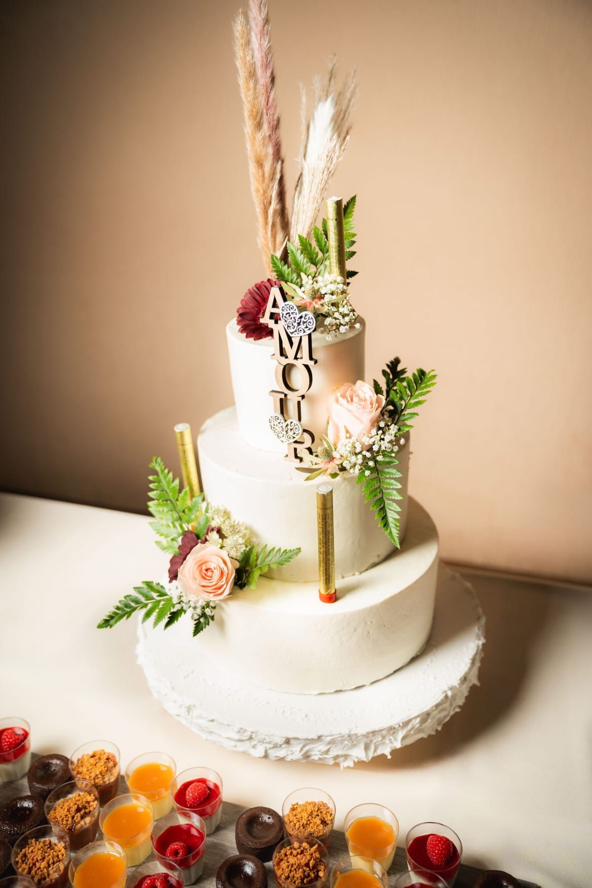 Un gâteau de mariage est posé sur une table à côté des desserts.