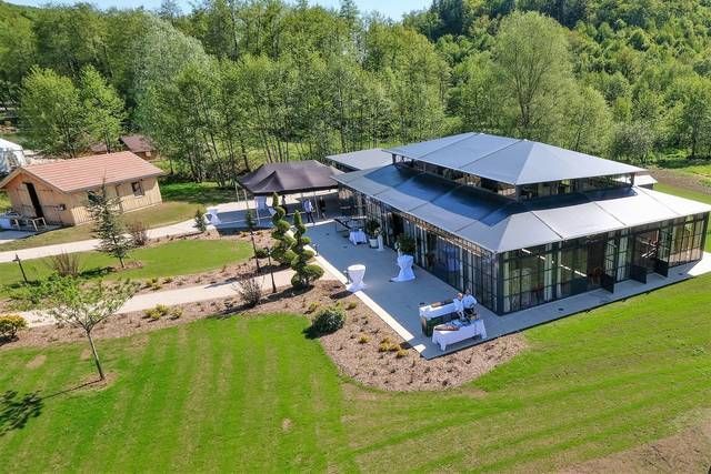 Une vue aérienne d'une grande maison au milieu d'un champ verdoyant.