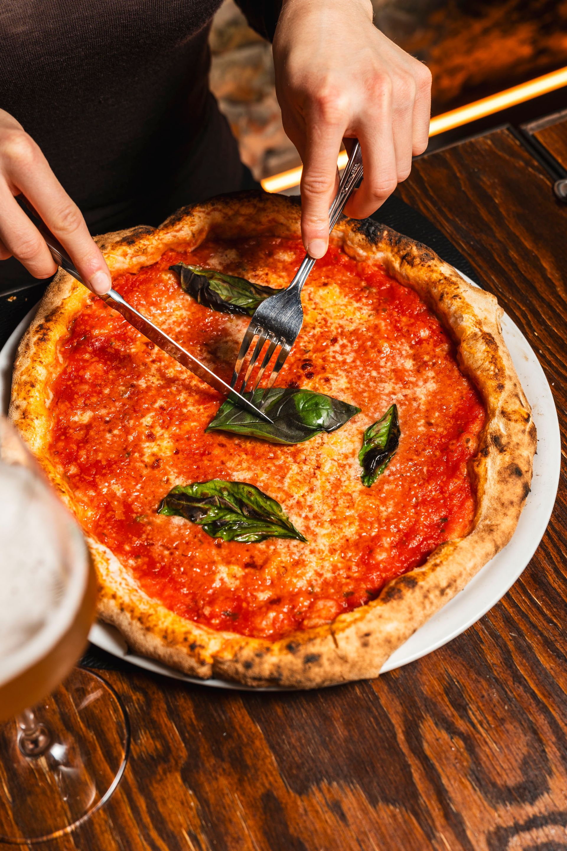 Pizza che cuoce in un forno a legna con le fiamme sullo sfondo