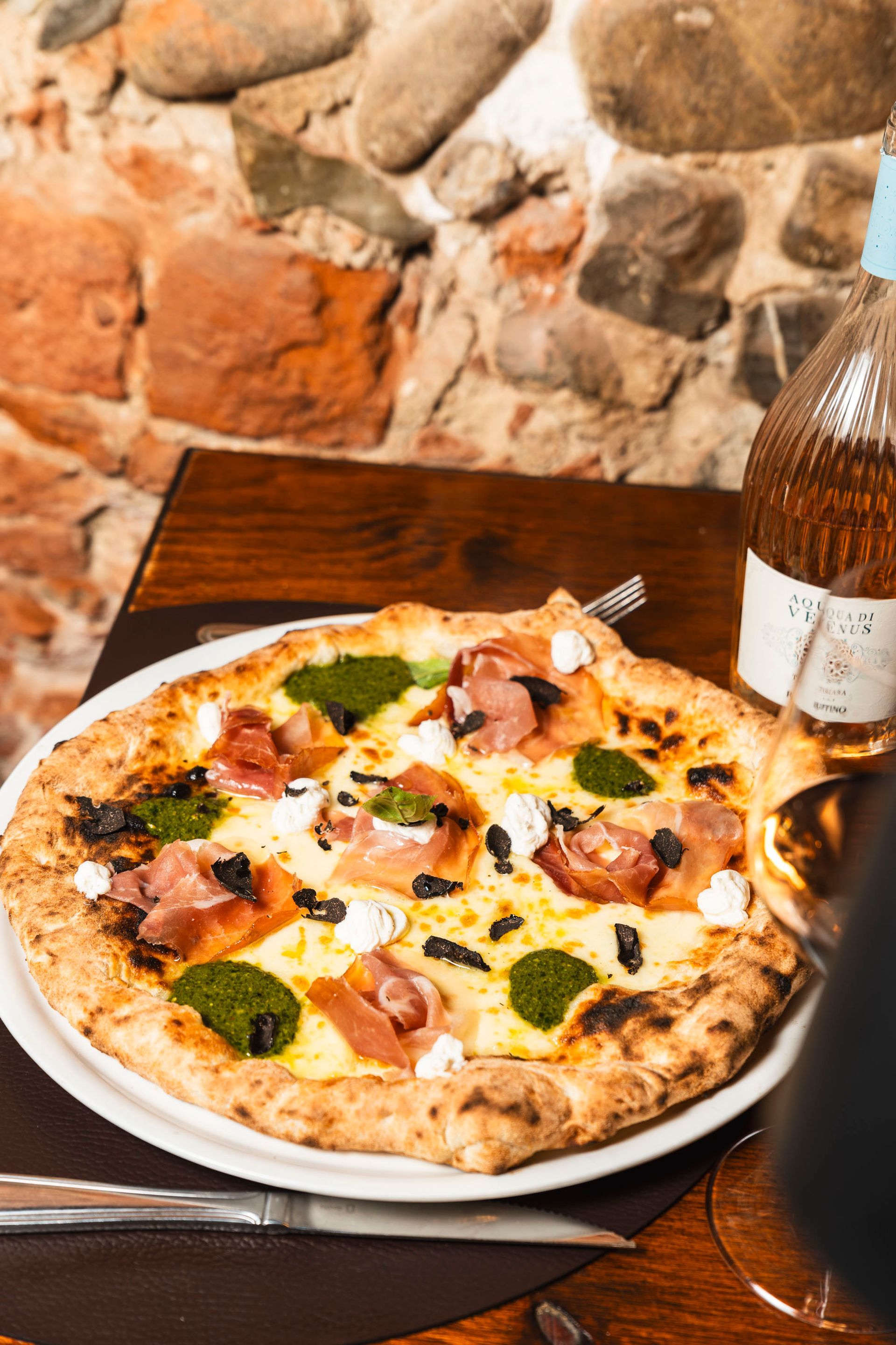 Pizza ricca di formaggio, condita con mais e prosciutto a cubetti su una crosta dorata.