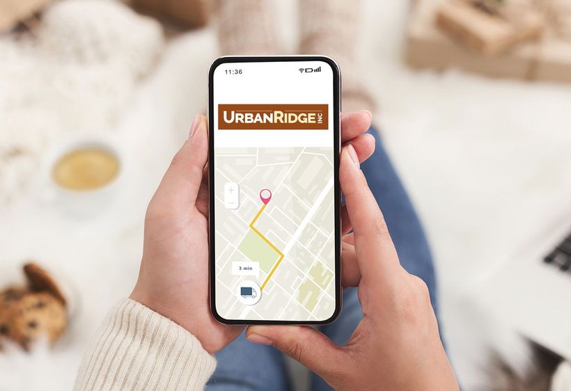 hands holding mobile phone with map to UrbanRidge Inc and logo