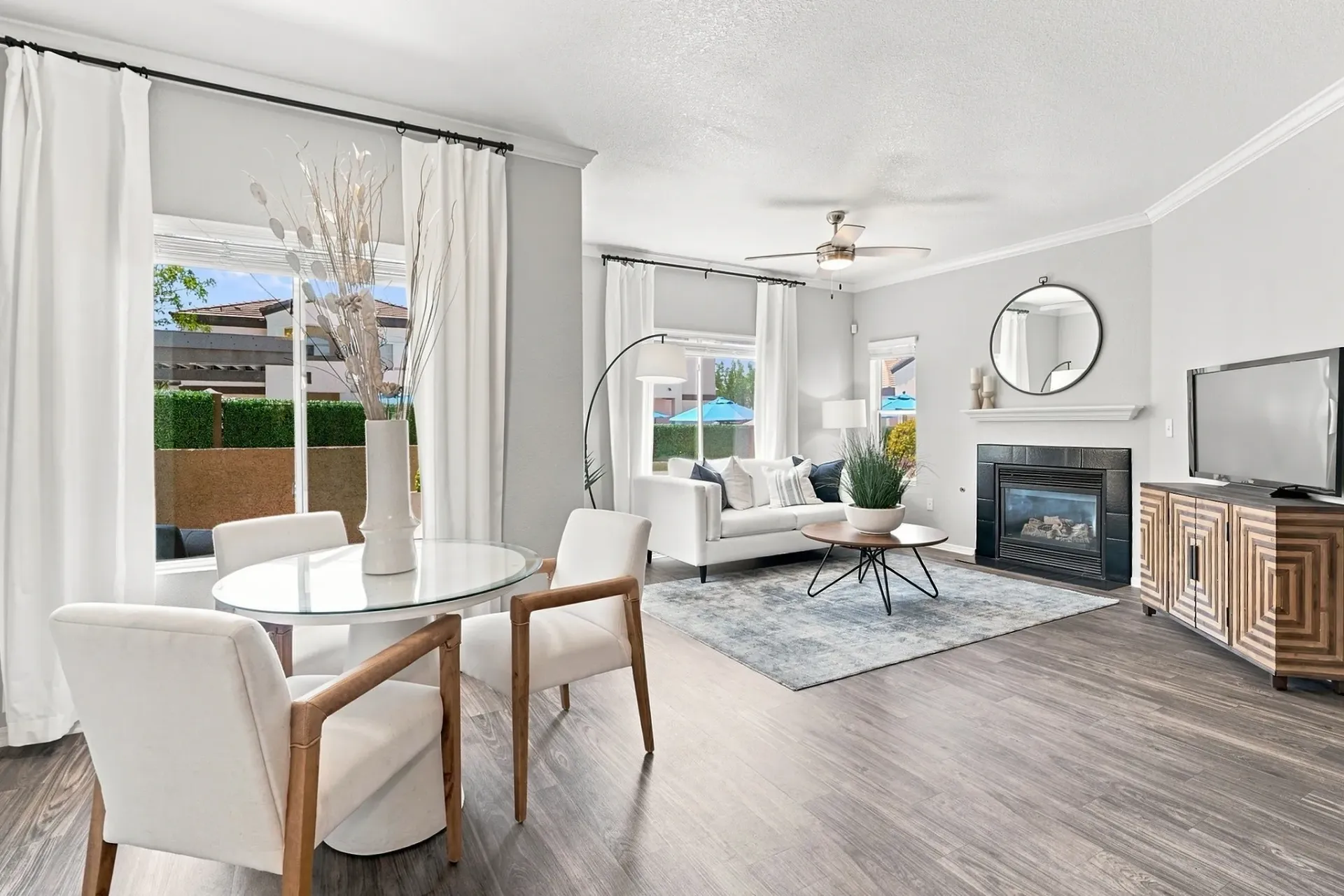 Modern living and dining area with a fireplace and TV.