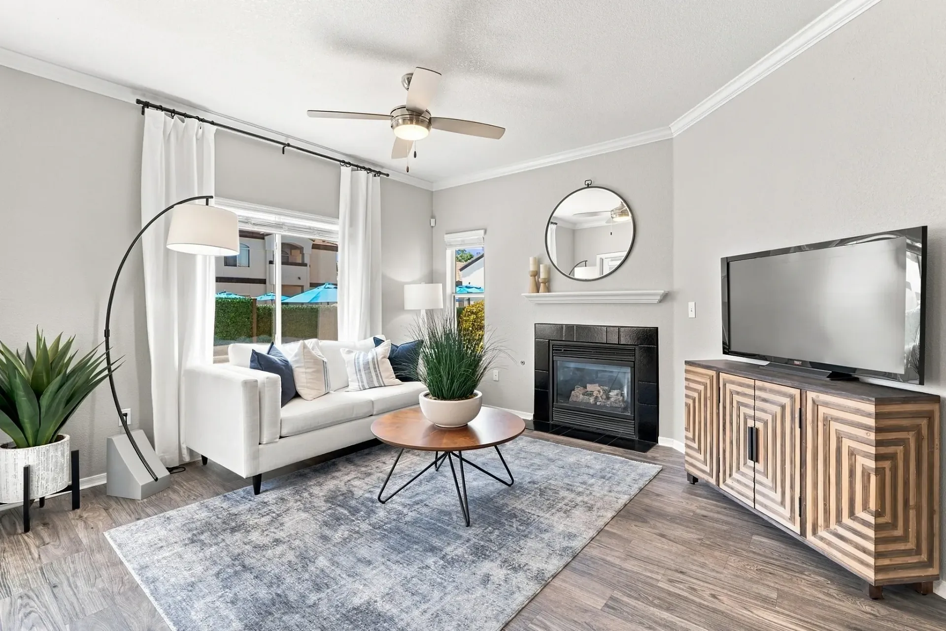 Spacious living room with a white sofa, coffee table, fireplace, and TV at Broadstone Heights, offering apartments in Albuquerque, NM.