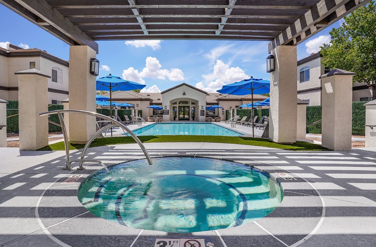 Outdoor pool and circular hot tub under a pergola at an apartment community at Broadstone Heights in Albuquerque, NM.