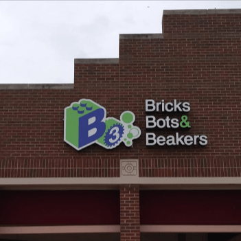 Bricks Bots & Beakers sign on a brick building facade with green and blue logo
