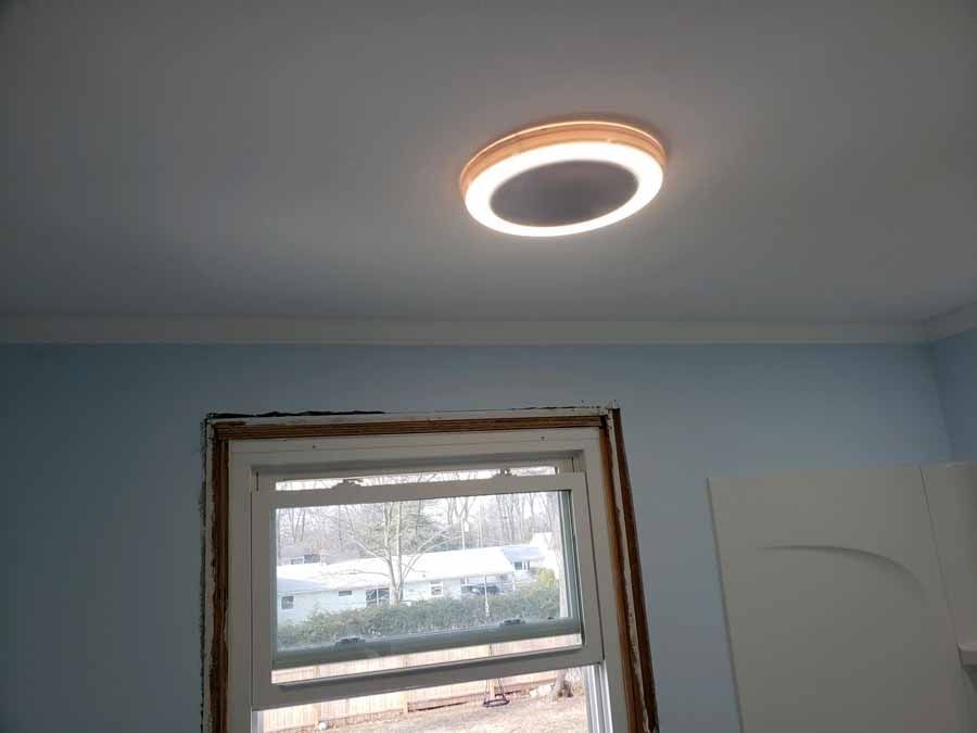 Ceiling light over a window in a room with blue walls, and a white ceiling.