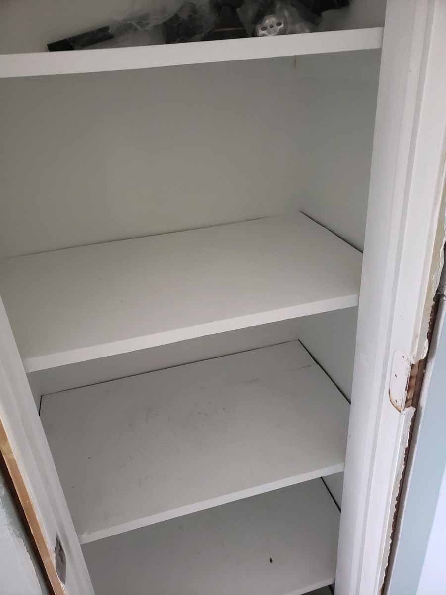 Empty white closet with three shelves.
