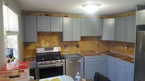Kitchen with light blue cabinets, stainless steel appliances, and exposed backsplash.