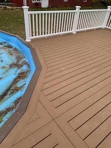 Brown deck with white railing surrounds a partially covered pool.