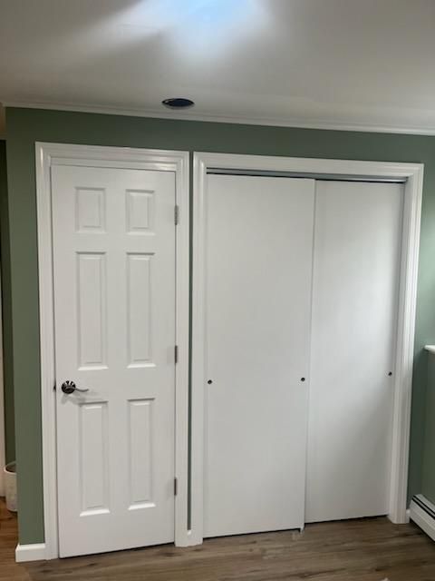 White door next to a sliding door closet in a room with green walls.