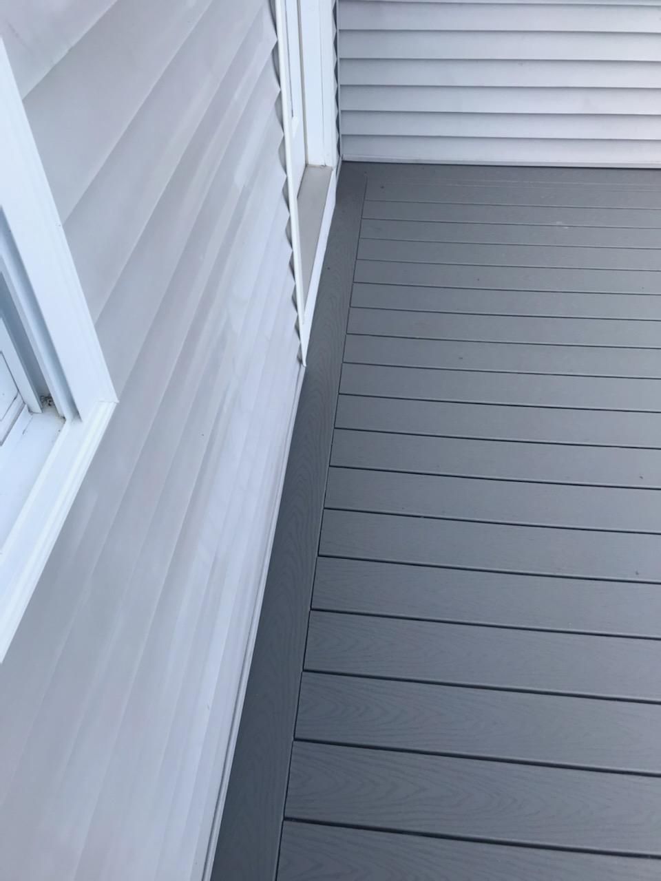 Gray siding meets a gray deck with a white trim.