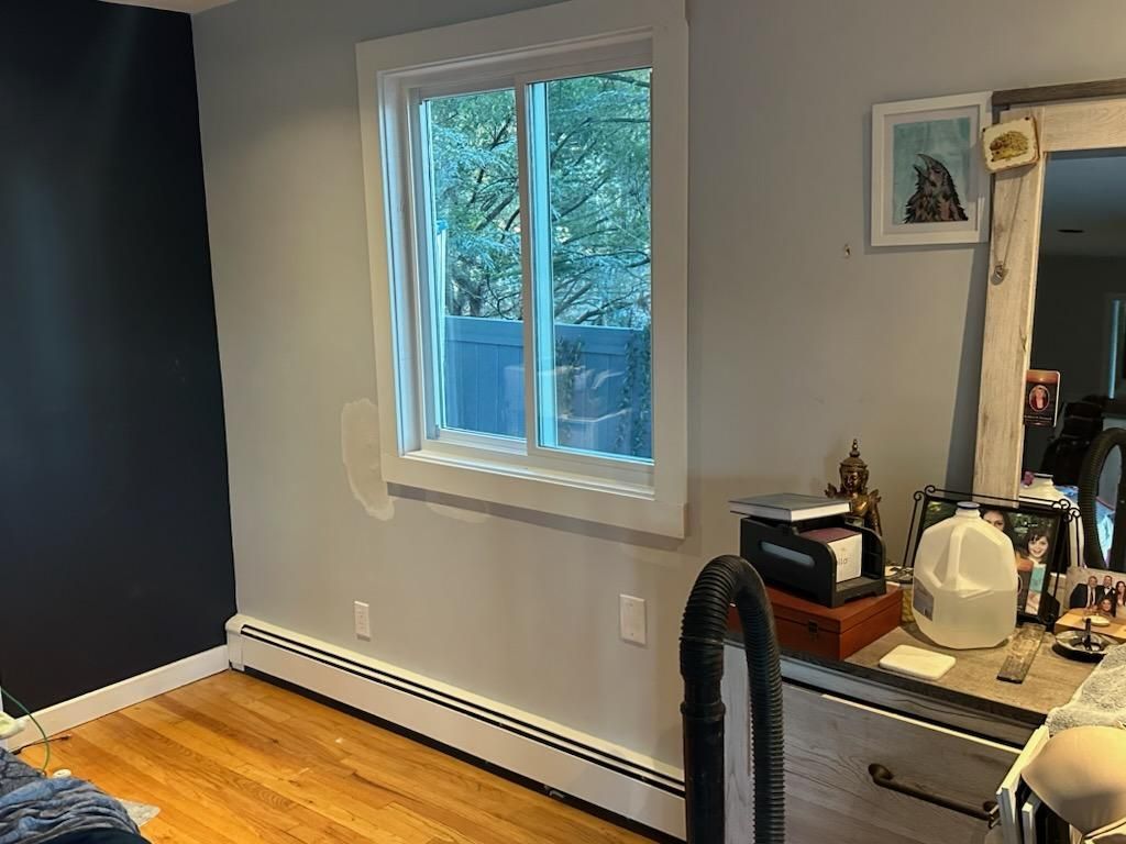Bedroom with a window, vanity, and a dark blue wall.
