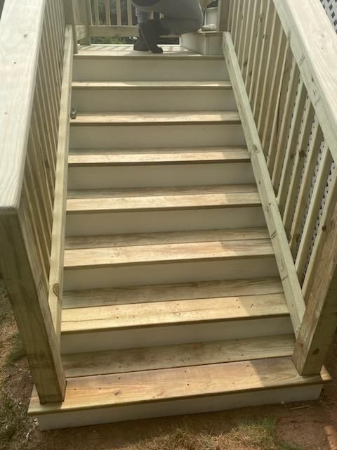 Wooden outdoor stairs with handrails leading upwards.