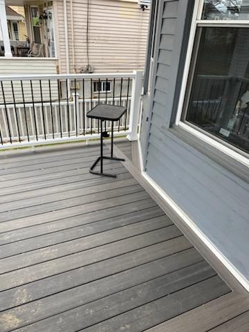Black stand on grey composite deck, next to a building with grey siding.