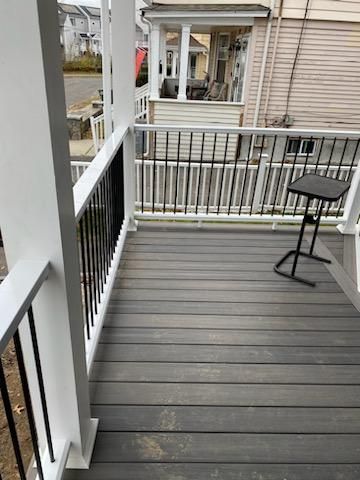 Gray composite deck with white and black railing. A small black table sits on the deck.