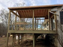 Wooden deck addition under construction, attached to a house.