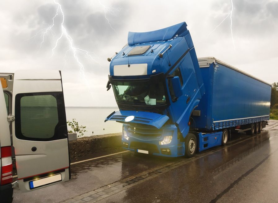 A blue truck is sitting on the side of the road next to a white van.