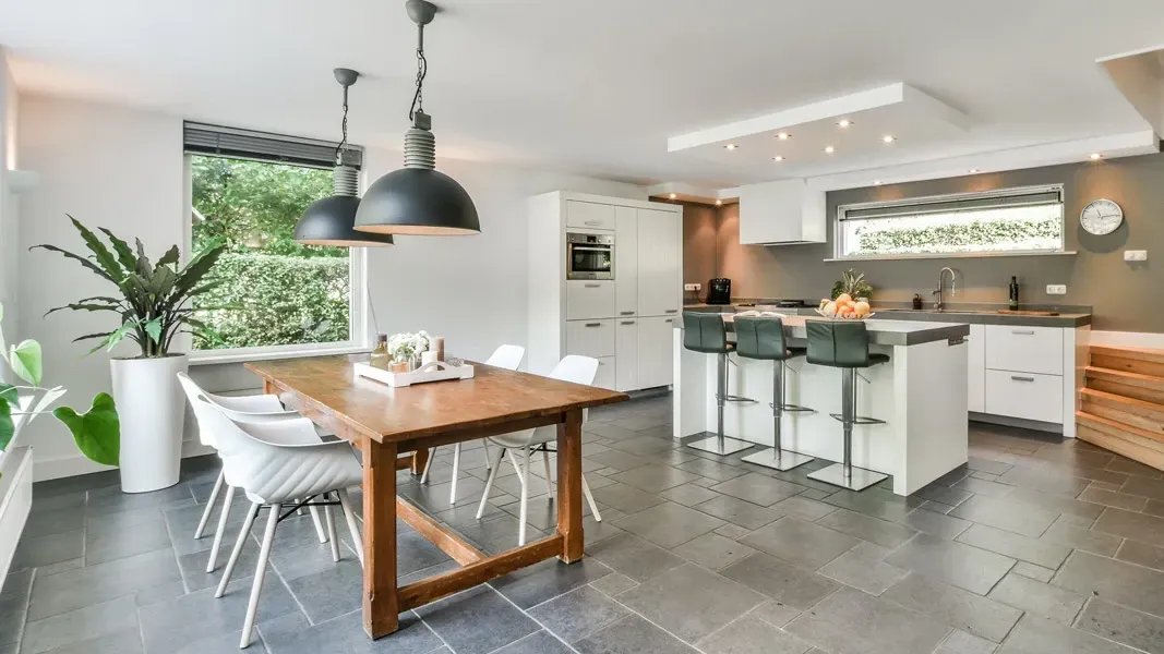 A kitchen and dining room with a wooden table and chairs.