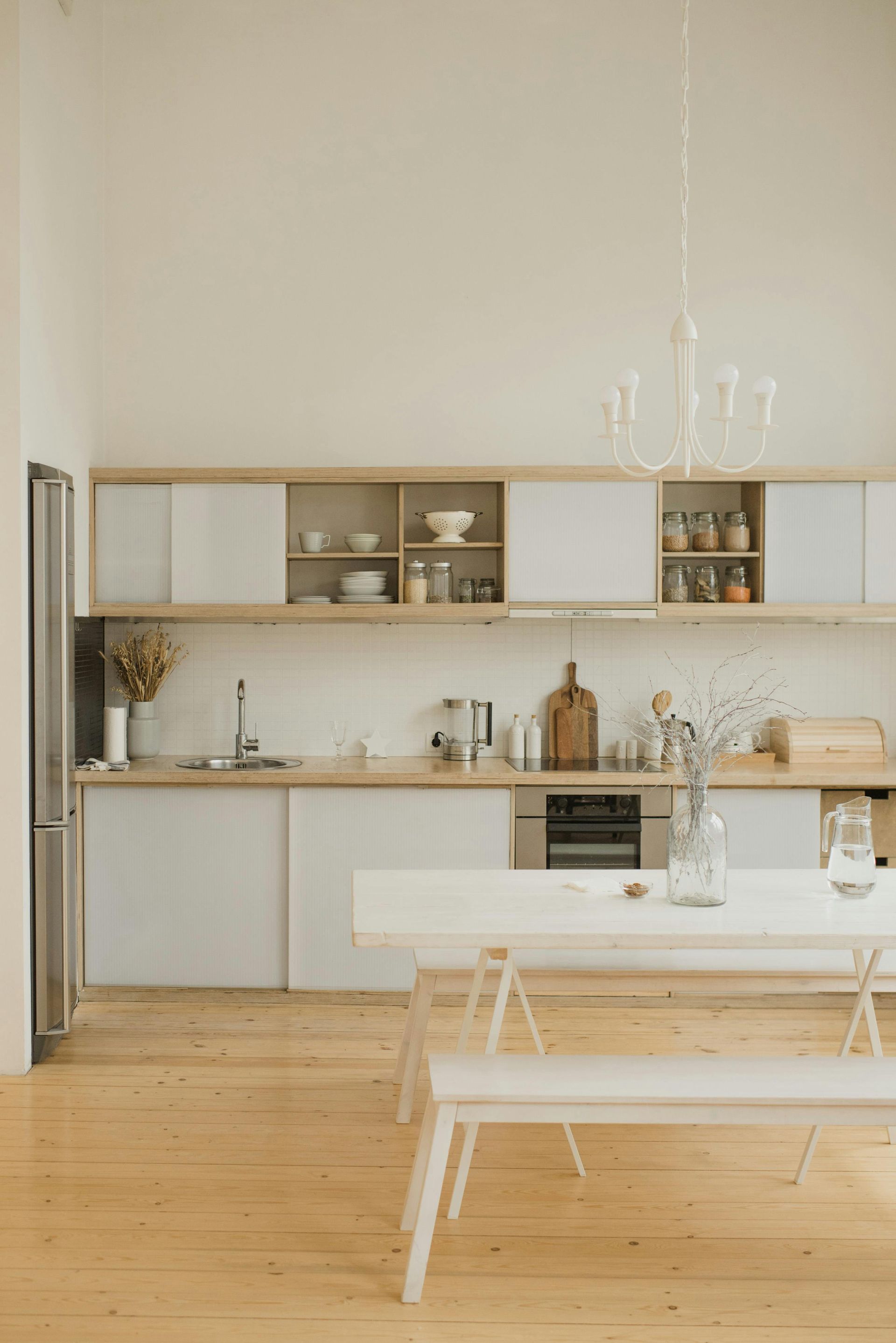 A kitchen with white cabinets , stainless steel appliances , a refrigerator and a stove