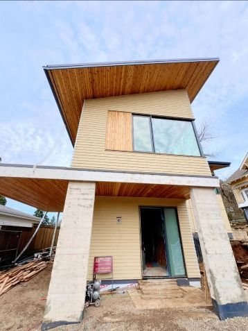 A small house with a wooden roof is being built.