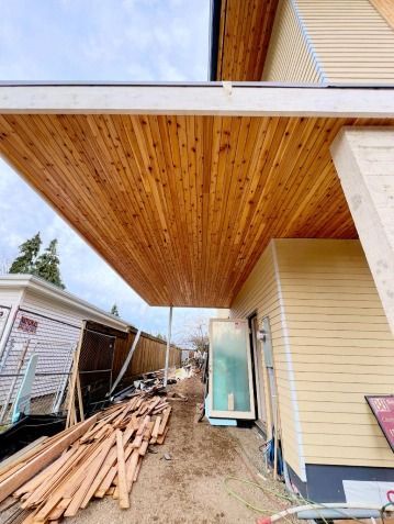 A wooden ceiling is being installed on the side of a house.