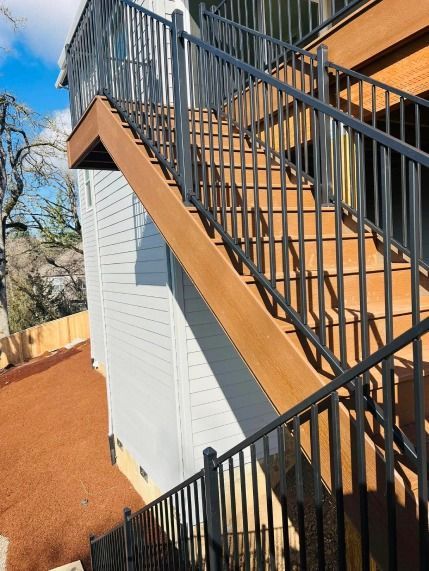 A set of stairs leading up to a balcony on the side of a house.