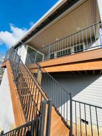 A house with a balcony and stairs leading up to it.