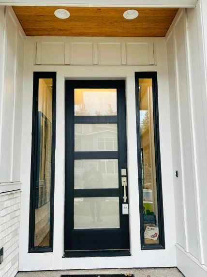 The front door of a white house with a black door