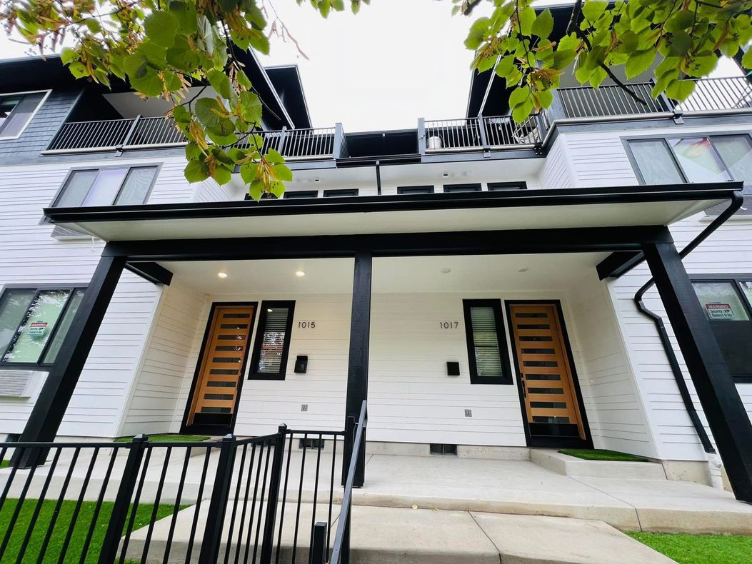A white house with a black porch and stairs