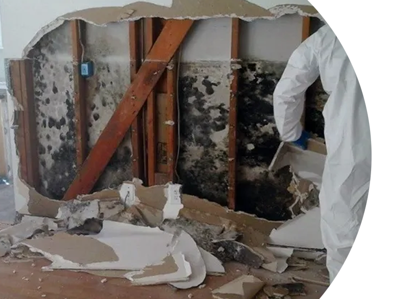 A man in a white suit is working on a wall