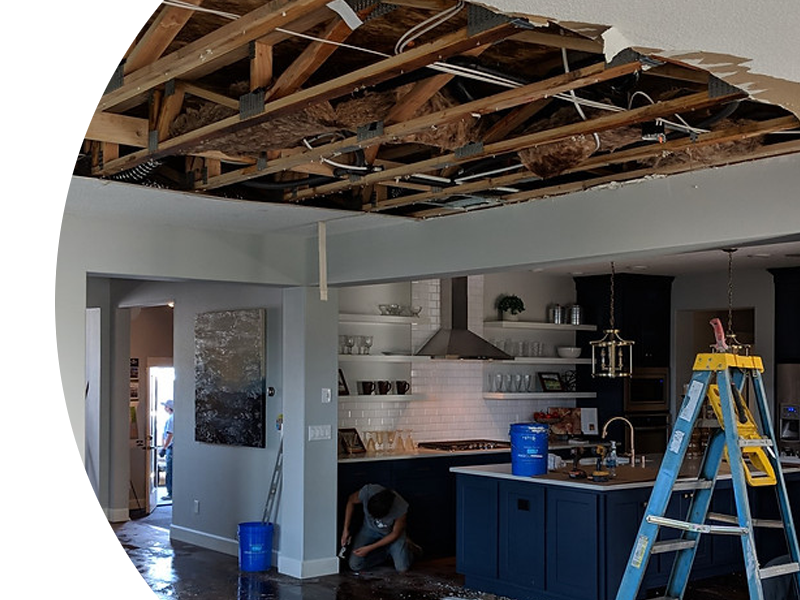 A man is working on the ceiling of a kitchen.