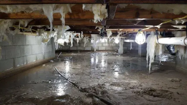 A flooded basement with ice hanging from the ceiling.