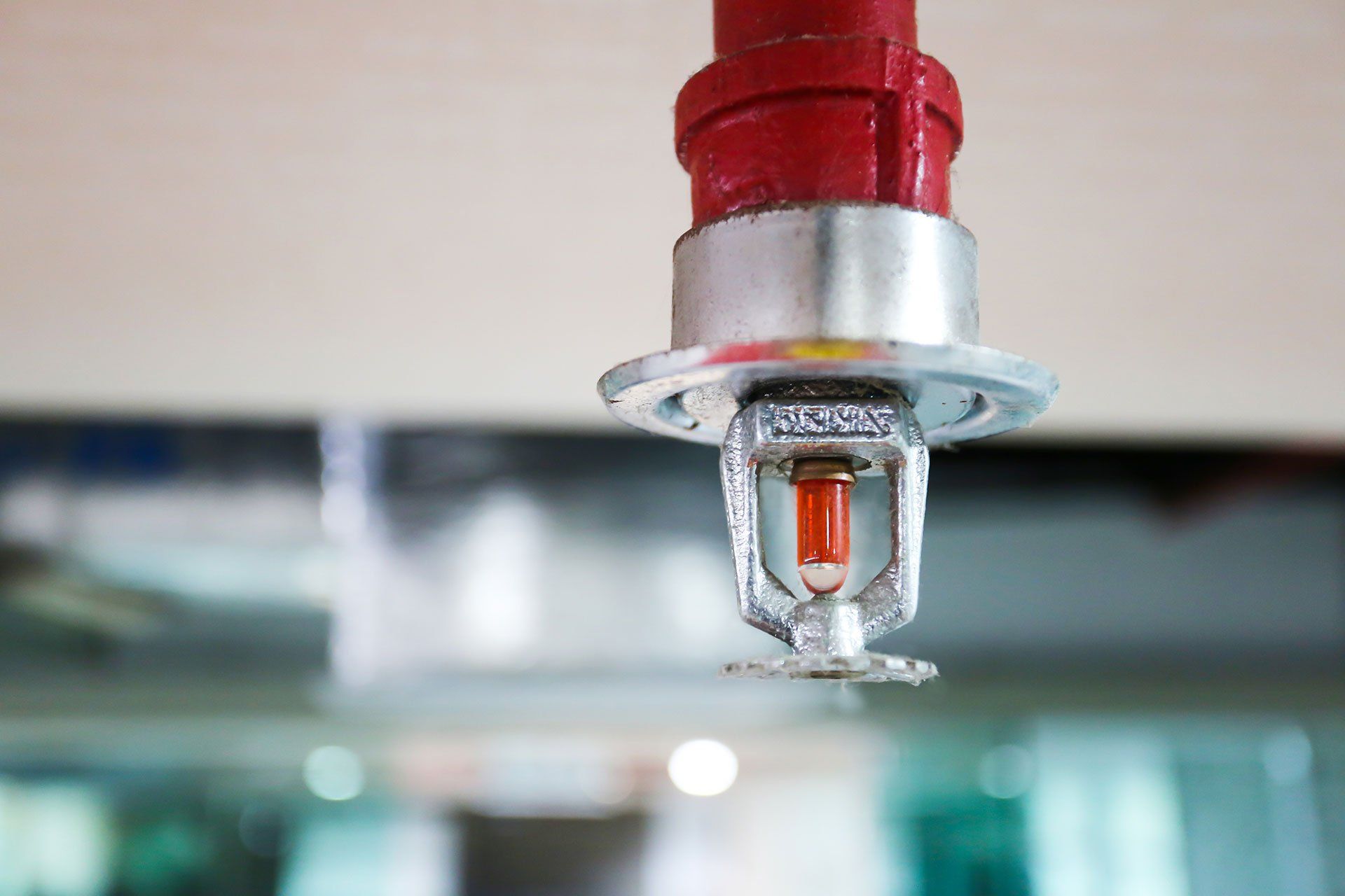 a fire sprinkler is hanging from the ceiling of a building .