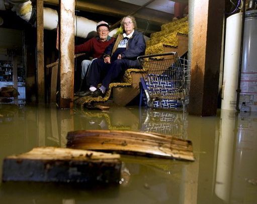 Elderly couple sitting in a flooded basement in Queens, NY