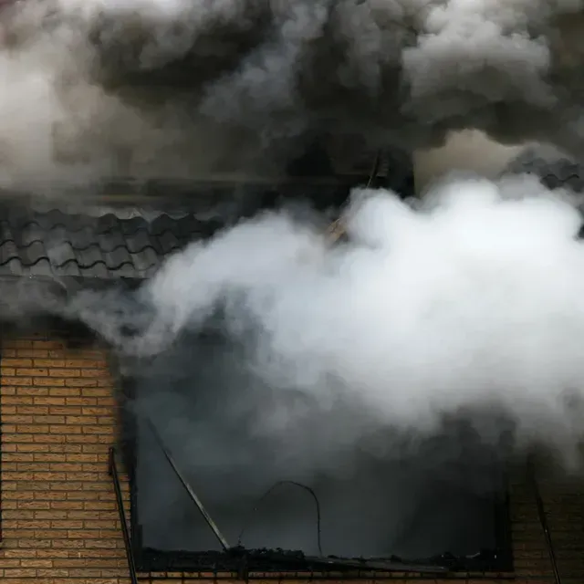 smoke pours out of a burning house in Queens, NY.